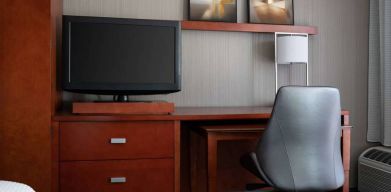 Sonesta Select Phoenix Camelback guest room workspace, including desk, chair, and lamp, plus a TV.