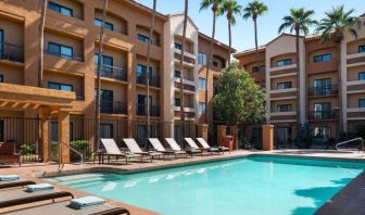 Sonesta Select Phoenix Camelback’s outdoor pool has sun loungers by the side, a shaded area, and tall palm trees.