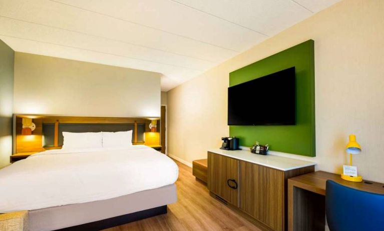 Double bed guest room in Sonesta Select Philadelphia Airport, with desk, chair, and a large television on the wall.