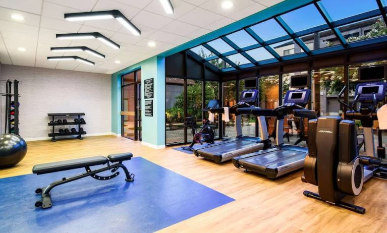 The fitness center at Sonesta Select Philadelphia Airport is equipped with free weights, an assortment of exercise machines, large windows, and gym balls.