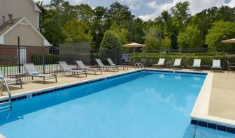 Sonesta ES Suites Raleigh Cary’s outdoor pool has shaded tables and chairs, and numerous sun loungers, by the side.