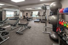 The fitness center at Sonesta ES Suites Fairfax Fair Lakes is equipped with dumbbells, kettlebells, gym balls, and assorted exercise machines.