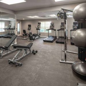 The fitness center at Sonesta ES Suites Fairfax Fair Lakes is equipped with dumbbells, kettlebells, gym balls, and assorted exercise machines.