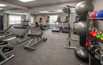 The fitness center at Sonesta ES Suites Fairfax Fair Lakes is equipped with dumbbells, kettlebells, gym balls, and assorted exercise machines.