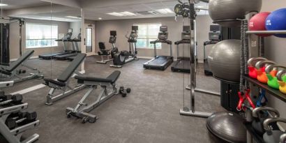 The fitness center at Sonesta ES Suites Fairfax Fair Lakes is equipped with dumbbells, kettlebells, gym balls, and assorted exercise machines.