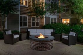 Sonesta ES Suites Fairfax Fair Lakes’ fire pit has armchairs, coffee tables, and a sofa where guests can relax and socialize.