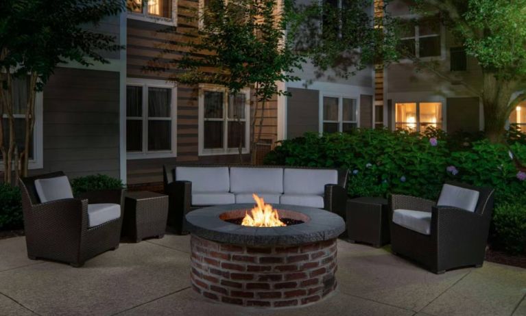 Sonesta ES Suites Fairfax Fair Lakes’ fire pit has armchairs, coffee tables, and a sofa where guests can relax and socialize.