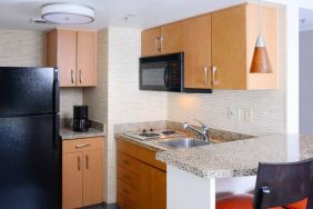 Sonesta ES Suites Dallas Medical Market Center guest room kitchen, with microwave, fridge-freezer, and hob.