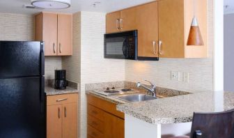 Sonesta ES Suites Dallas Medical Market Center guest room kitchen, with microwave, fridge-freezer, and hob.