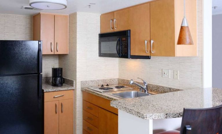 Sonesta ES Suites Dallas Medical Market Center guest room kitchen, with microwave, fridge-freezer, and hob.