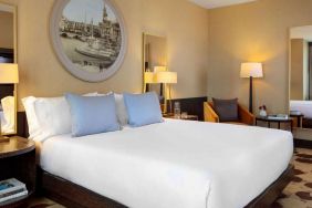 Royal Sonesta Chicago River North double bed guest room, furnished with bedside lamps, coffee table, and an armchair.