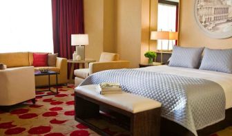 Royal Sonesta Chicago River North double bed guest room featuring chairs, coffee table, window, and a sofa.