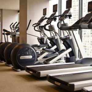 The hotel fitness center is equipped with a range of exercise machines, and large windows with city views.