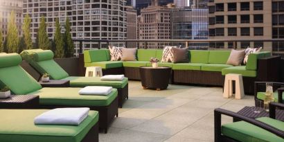 Royal Sonesta Chicago River North’s patio is furnished with chairs, loungers, and sofas, and offers city views.