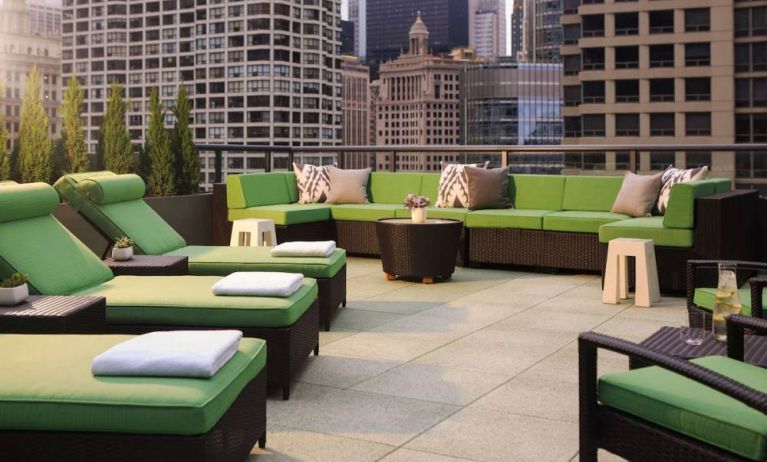 Royal Sonesta Chicago River North’s patio is furnished with chairs, loungers, and sofas, and offers city views.