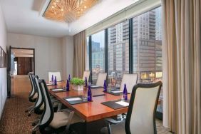 Hotel meeting room, with long wooden table, eight swivel chairs, and floor-to-ceiling windows.