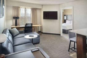 Double bed guest room living area in Sonesta ES Suites Raleigh Durham Airport Morrisville, with sofa, window, and TV.