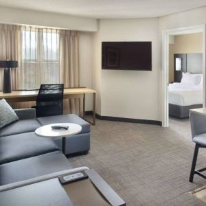 Double bed guest room living area in Sonesta ES Suites Raleigh Durham Airport Morrisville, with sofa, window, and TV.