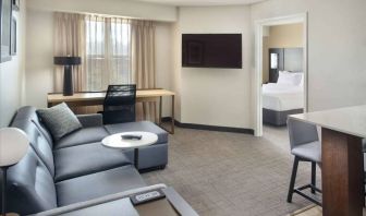 Double bed guest room living area in Sonesta ES Suites Raleigh Durham Airport Morrisville, with sofa, window, and TV.