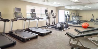 Sonesta ES Suites Raleigh Durham Airport Morrisville’s fitness center is equipped with free weights, benches, and various exercise machines.