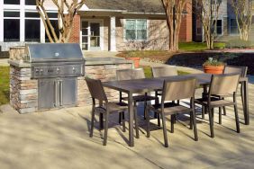 Barbecue with table and six chairs nearby at Sonesta ES Suites Raleigh Durham Airport Morrisville.