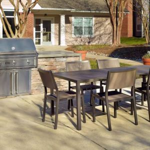 Barbecue with table and six chairs nearby at Sonesta ES Suites Raleigh Durham Airport Morrisville.