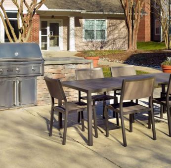 Barbecue with table and six chairs nearby at Sonesta ES Suites Raleigh Durham Airport Morrisville.