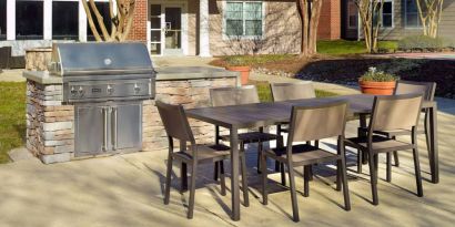 Barbecue with table and six chairs nearby at Sonesta ES Suites Raleigh Durham Airport Morrisville.