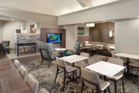 Lobby lounge furnished with sofa seating, tables and chairs, a fireplace and TV, at Sonesta ES Suites Raleigh Durham Airport Morrisville.