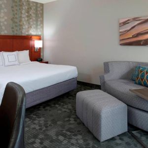 Sonesta Select Kansas City Airport Tiffany Springs double bed guest room furnished with art on the wall and a sofa.