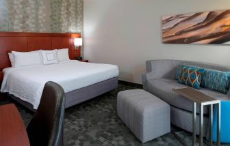 Sonesta Select Kansas City Airport Tiffany Springs double bed guest room furnished with art on the wall and a sofa.