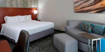 Sonesta Select Kansas City Airport Tiffany Springs double bed guest room furnished with art on the wall and a sofa.