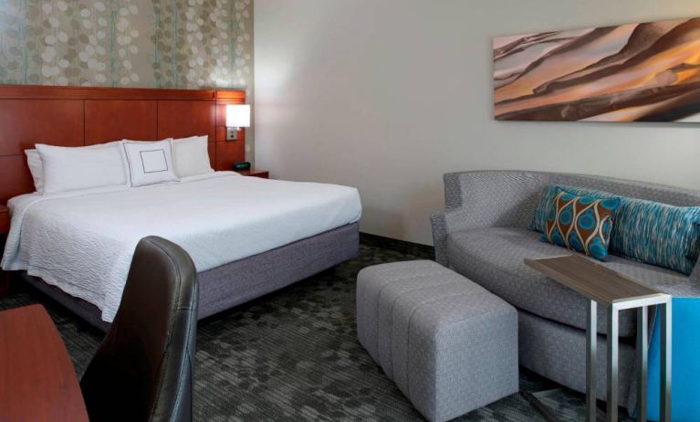 Sonesta Select Kansas City Airport Tiffany Springs double bed guest room furnished with art on the wall and a sofa.