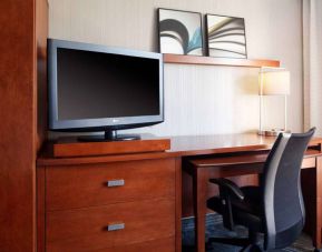 Guest room workspace desk, chair, lamp, and TV at Sonesta Select Kansas City Airport Tiffany Springs.