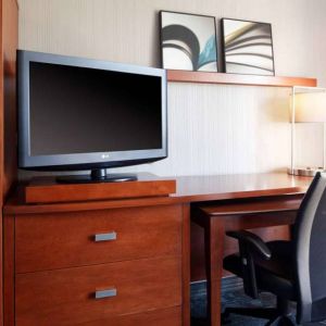 Guest room workspace desk, chair, lamp, and TV at Sonesta Select Kansas City Airport Tiffany Springs.