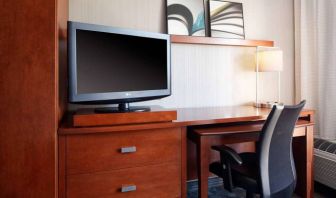 Guest room workspace desk, chair, lamp, and TV at Sonesta Select Kansas City Airport Tiffany Springs.