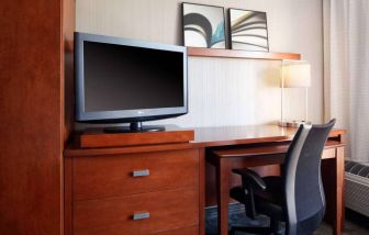 Guest room workspace desk, chair, lamp, and TV at Sonesta Select Kansas City Airport Tiffany Springs.