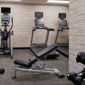 Fitness center equipped with free weights and assorted exercise machines at Sonesta Select Kansas City Airport Tiffany Springs.