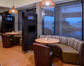 The hotel’s media pods each provide comfy seating, a TV, and a coffee table for socializing and co-working.