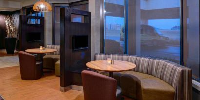 The hotel’s media pods each provide comfy seating, a TV, and a coffee table for socializing and co-working.