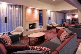 Sonesta Select Kansas City Airport Tiffany Springs’ lobby lounge is furnished with comfy chairs and sofa seating, and a fireplace.