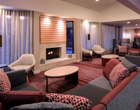 Sonesta Select Kansas City Airport Tiffany Springs’ lobby lounge is furnished with comfy chairs and sofa seating, and a fireplace.