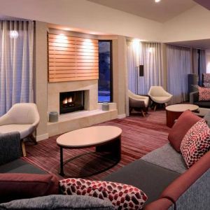 Sonesta Select Kansas City Airport Tiffany Springs’ lobby lounge is furnished with comfy chairs and sofa seating, and a fireplace.