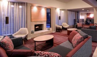 Sonesta Select Kansas City Airport Tiffany Springs’ lobby lounge is furnished with comfy chairs and sofa seating, and a fireplace.