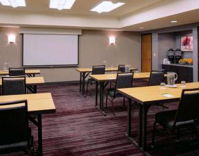 Hotel meeting room, with tables arranged in a classroom format facing a projector screen.