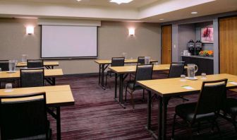 Hotel meeting room, with tables arranged in a classroom format facing a projector screen.