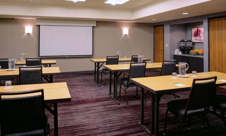 Hotel meeting room, with tables arranged in a classroom format facing a projector screen.