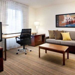 Guest room workspace desk and chair, with TV and sofa nearby, at Sonesta ES Suites San Antonio Downtown Alamo Plaza.