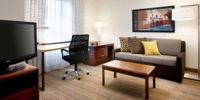 Guest room workspace desk and chair, with TV and sofa nearby, at Sonesta ES Suites San Antonio Downtown Alamo Plaza.