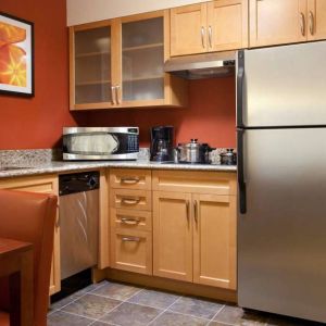 Guest room kitchen fitted with microwave, fridge-freezer, hob, and table at Sonesta ES Suites San Antonio Downtown Alamo Plaza.